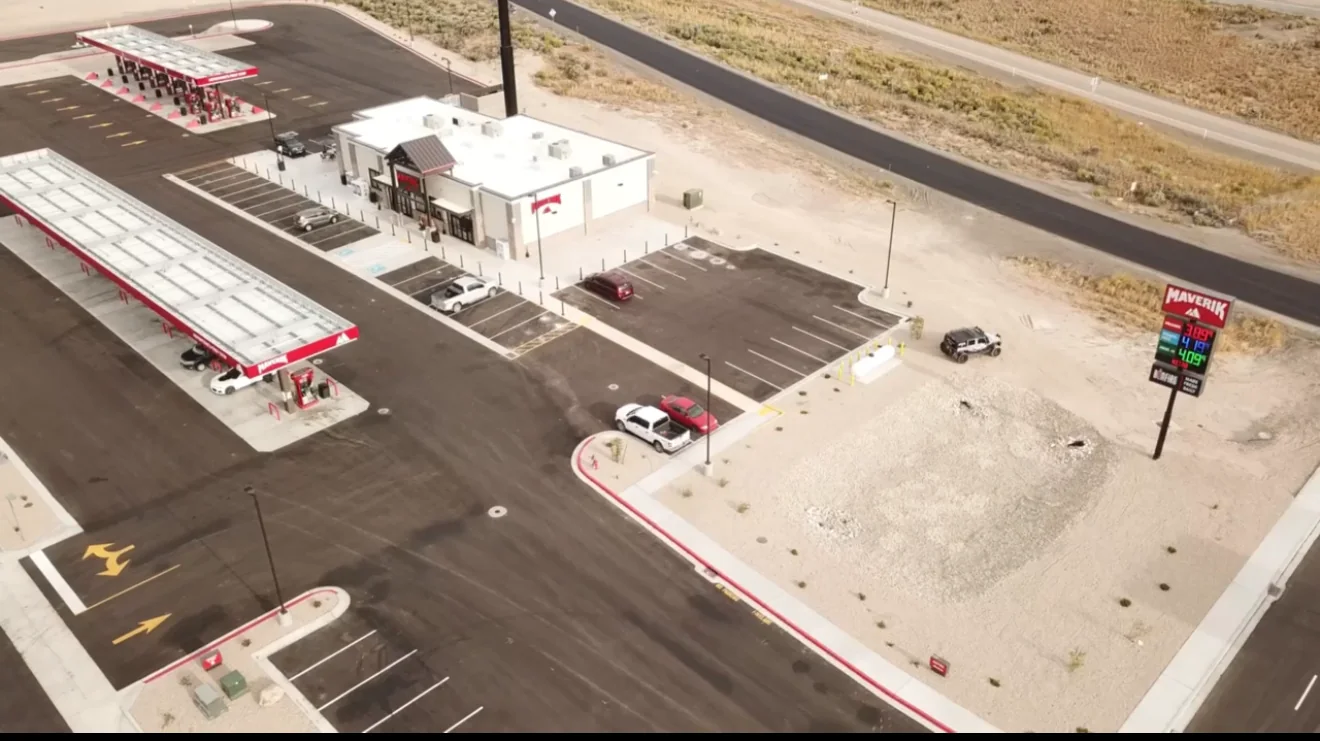 Aerial view of a commercial property with parking, curbed planting areas and adjoining roads.